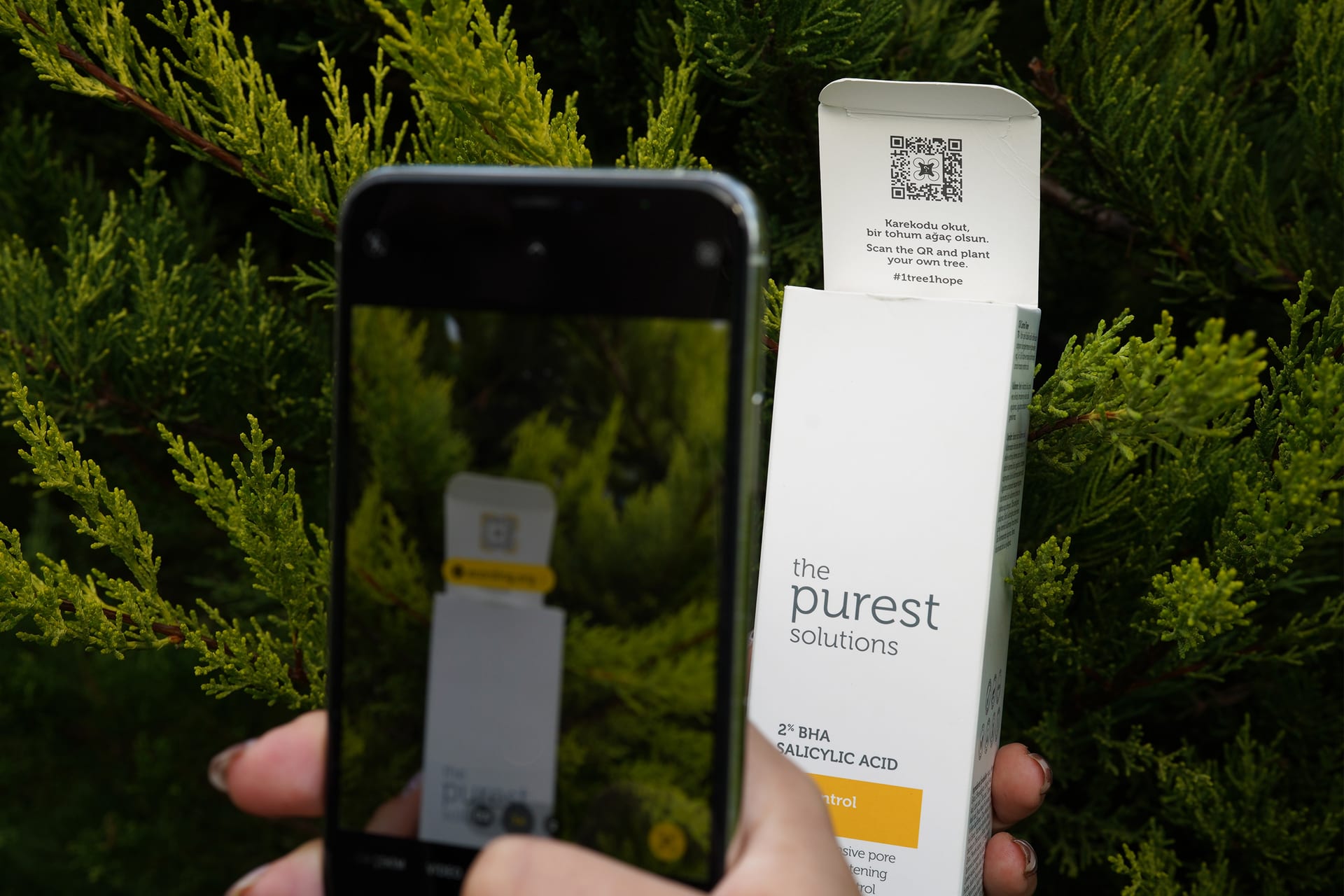 A phone scanning a contribution QR code on product packaging