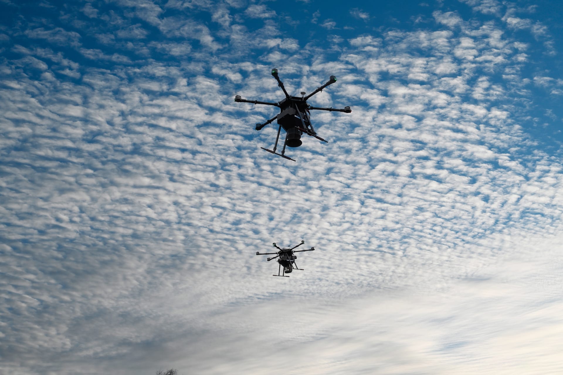 Two ecoDrones flying against a cloudy sky